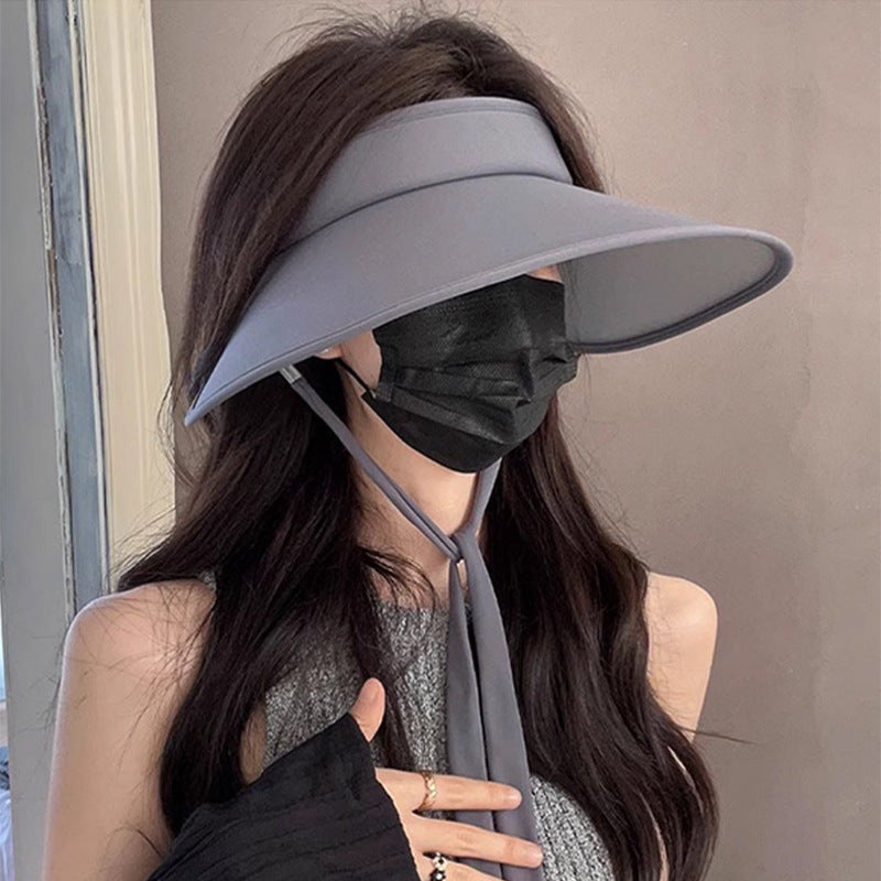 Packable sun hat for women styled with sunglasses and activewear.